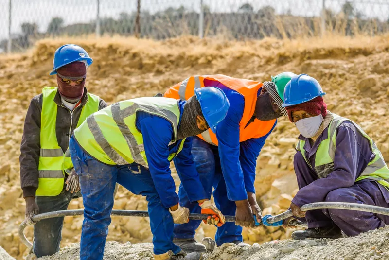 Workers in high-visibility clothing and safety helmets