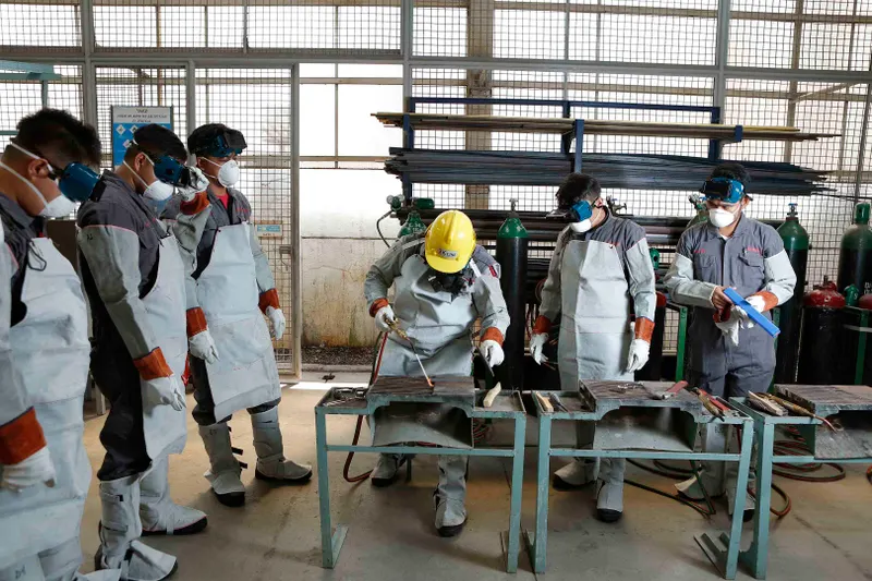 Plant operators in protective equipment working on a filling line